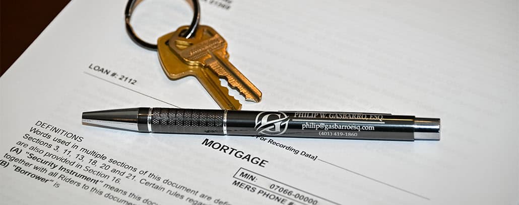 Pen and keys laying on top of a mortgage contract.