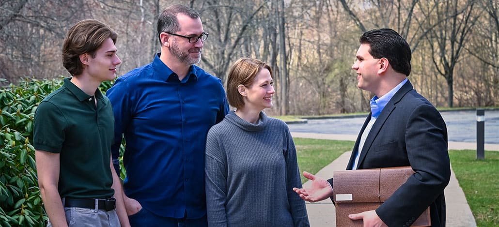 Real estate attorney meeting with buyers outside their new home.